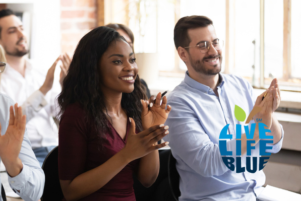 Man and woman at employee awards ceremony with Live Life Blue logo