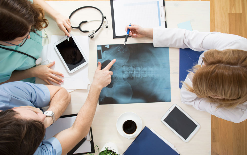 overhead view of doctors look at back x-ray