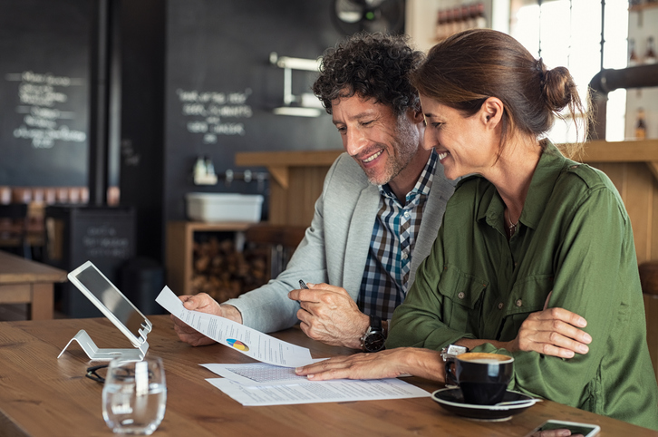 Man and woman reviewing paperwork at a cafe